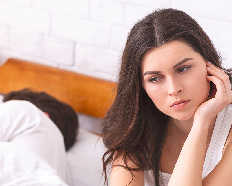 Woman sitting on the bed feeling frustrated by sexual issues and thinking about therapy for sexual issues in Las Vegas